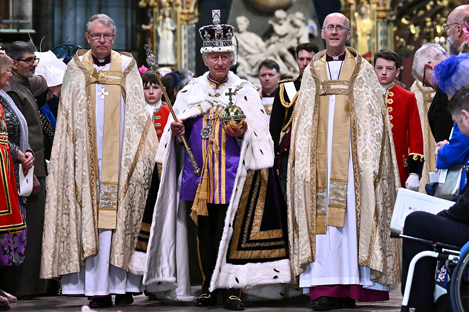 King Charles III wearing the Imperial state Crown and carrying the Sovereign's Orb and Sceptre leaves Westminster Abbey after coronation in central London