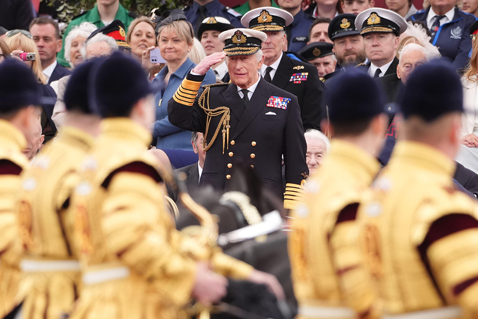King Charles III takes the salute from the military procession for the 80th anniversary of VE Day, at Buckingham Palace in central London.